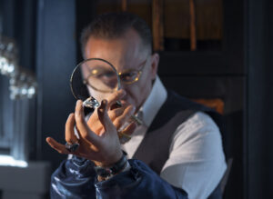 The jeweler enthusiastically considering large gem | post my gold - sell your jewellery online