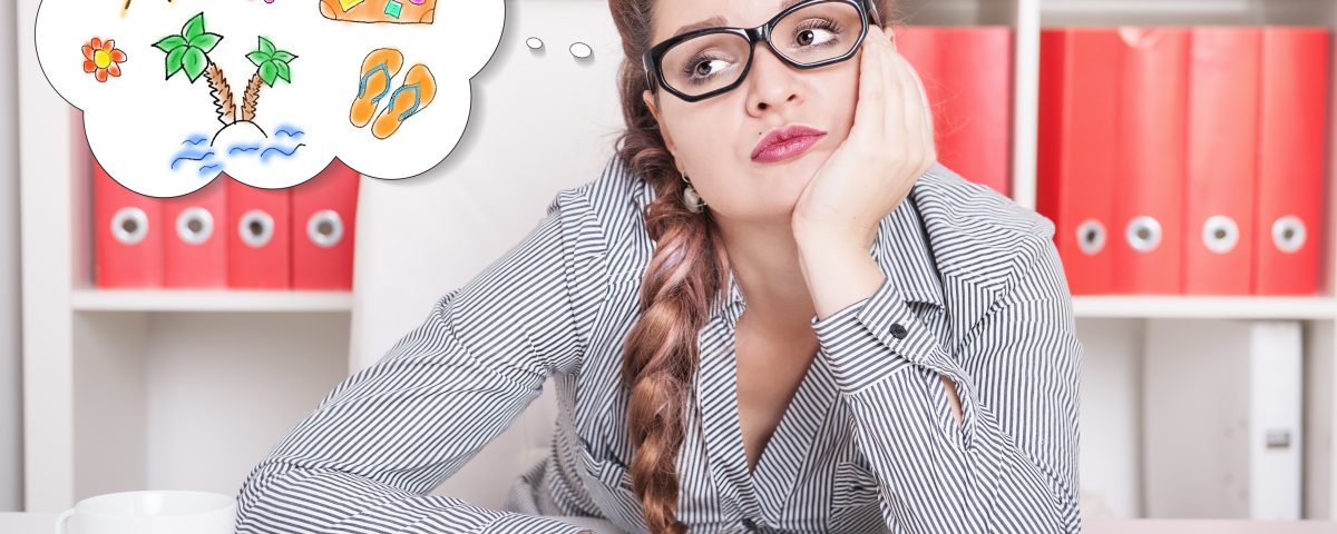 woman day dreaming of a holiday vacation while at work | Sell your jewellery at Post My Gold