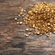 A pile of gold pieces on a wooden background. Post gold for cash amounts.