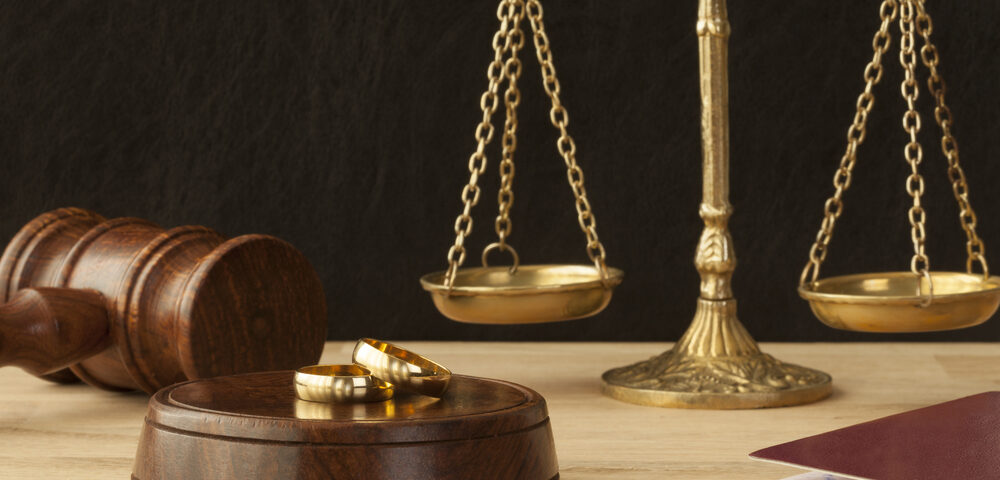 Weighing scales with two gold rings in the foreground. Sell jewellery for cash.