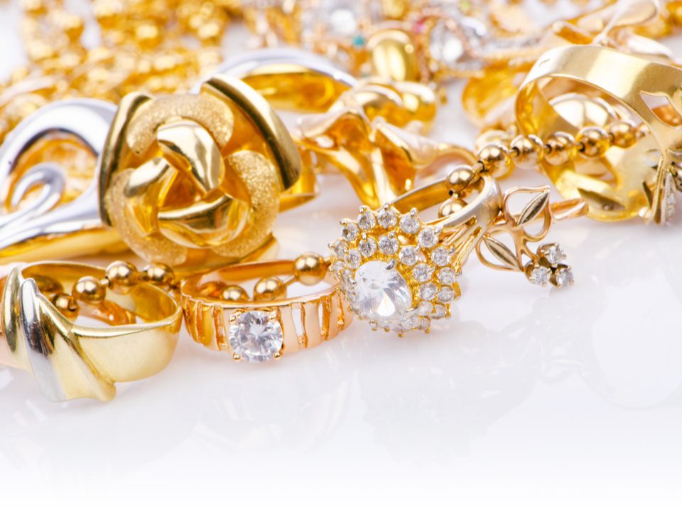 Selection of expensive gold jewellery on a white table