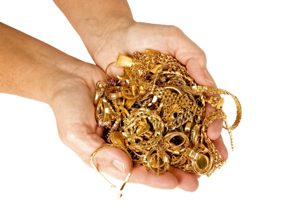 Woman holding a pile of gold jewellery
