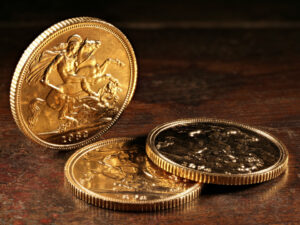 Three gold sovereign coins on a mahogany table
